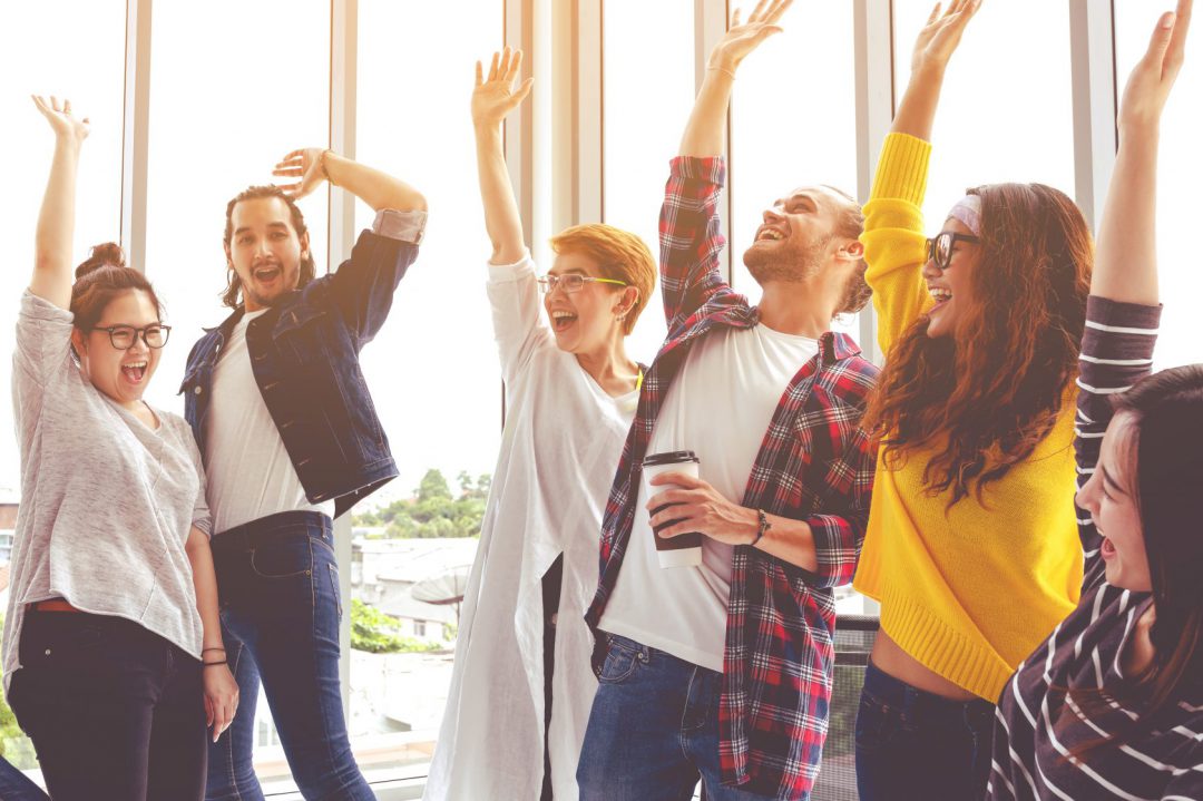 Banner of Young multiethnic diverse creative asian group huddle and high five hands together in office workshop with success or empower expression in teamwork. Young asian marketing team.